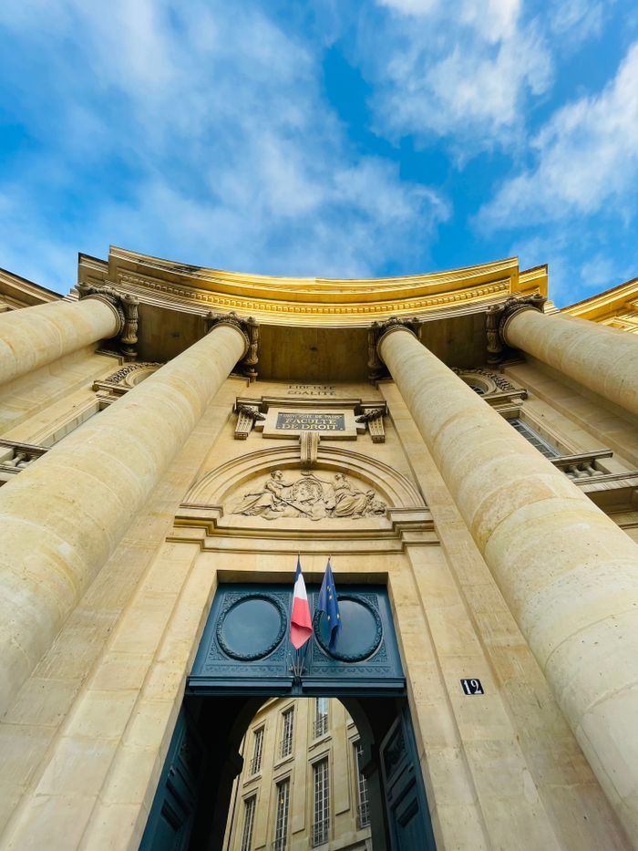 Explore the grand architecture of the Paris Law Faculty with its imposing columns and blue sky backdrop.